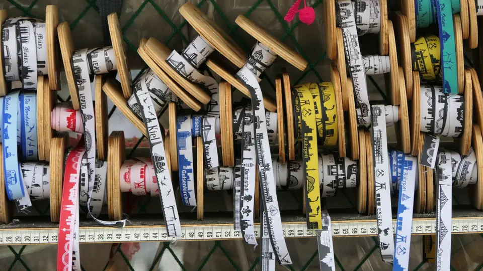 Eine Auswahl an Farbbändern mit Stadtsilhouettenmotiven in einem Ladendisplay.